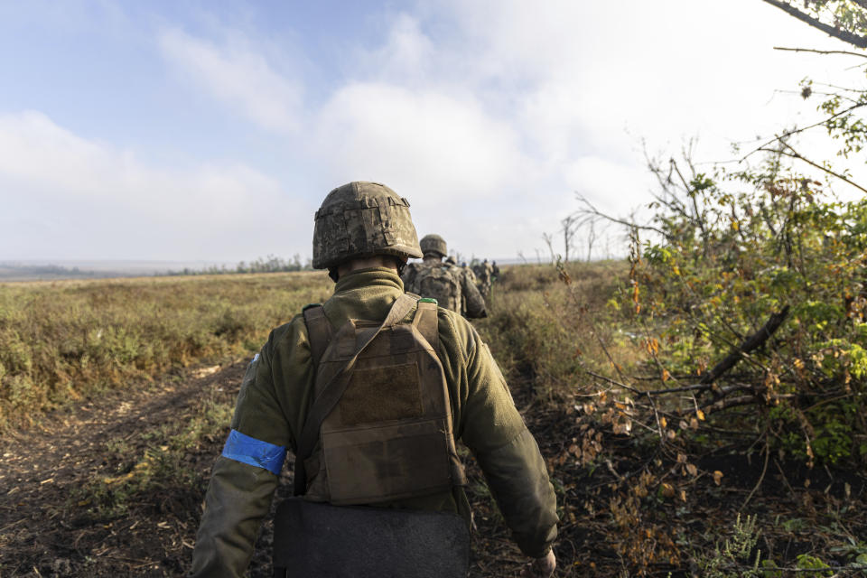 A group of Ukrainian servicemen from 3rd Assault brigade move to take a new position at the frontline a few kilometers from Andriivka, Donetsk region, Ukraine, Saturday, Sept. 16, 2023. The 3rd Assault Brigade said it took the village after surrounding the Russian garrison in the settlement during what it described as a "lightning operation" and destroying it over two days. (AP Photo/Alex Babenko).