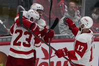 Detroit Red Wings right wing Lucas Raymond (23), center Dylan Larkin (71) and defenseman Filip Hronek (17) celebrate the game-wining goal by Larkin after an NHL hockey game against the Washington Capitals, Wednesday, Oct. 27, 2021, in Washington. The Red Wings won 3-2 in overtime. (AP Photo/Alex Brandon)