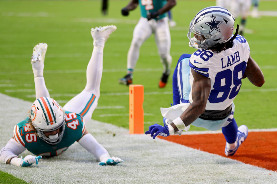 MIAMI GARDENS, FLORIDA - DECEMBER 24: CeeDee Lamb #88 of the Dallas Cowboys scores a touchdown while defended by Duke Riley #45 of the Miami Dolphins during the first quarter at Hard Rock Stadium on December 24, 2023 in Miami Gardens, Florida. (Photo by Stacy Revere/Getty Images)