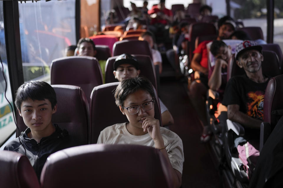 Chinese migrant Liu Tiantian, second from left, sits on a bus to Costa Rica after walking across the Darien Gap with her father and brother in Lajas Blancas, Panama, Thursday, June 27, 2024. (AP Photo/Matias Delacroix)