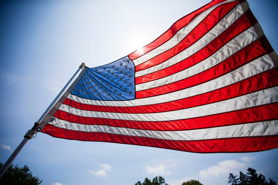 In this file photo, an American flag waves in the wind near the Veterans Memorial at the cemetery before the Fourth of July parade in North Liberty on July 4, 2017.