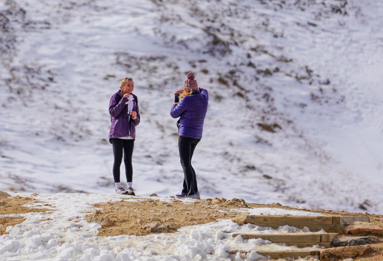 North Carolina resident Ellie Rose Brownfield, 15, poses for a photo with a paper cutout of King Charles IV of Austria, as her mom Andrea Brownfield, takes a photo. The two climbed onto the Continental Divide at Loveland Pass during a visit to Colorado on Nov. 6, 2023. Brownfield said she was competing with classmates to take a picture with the cutout with the best background for a school assignment. Water from here will flow either east to the Gulf of Mexico or west down the Colorado River to California and then into Mexico.