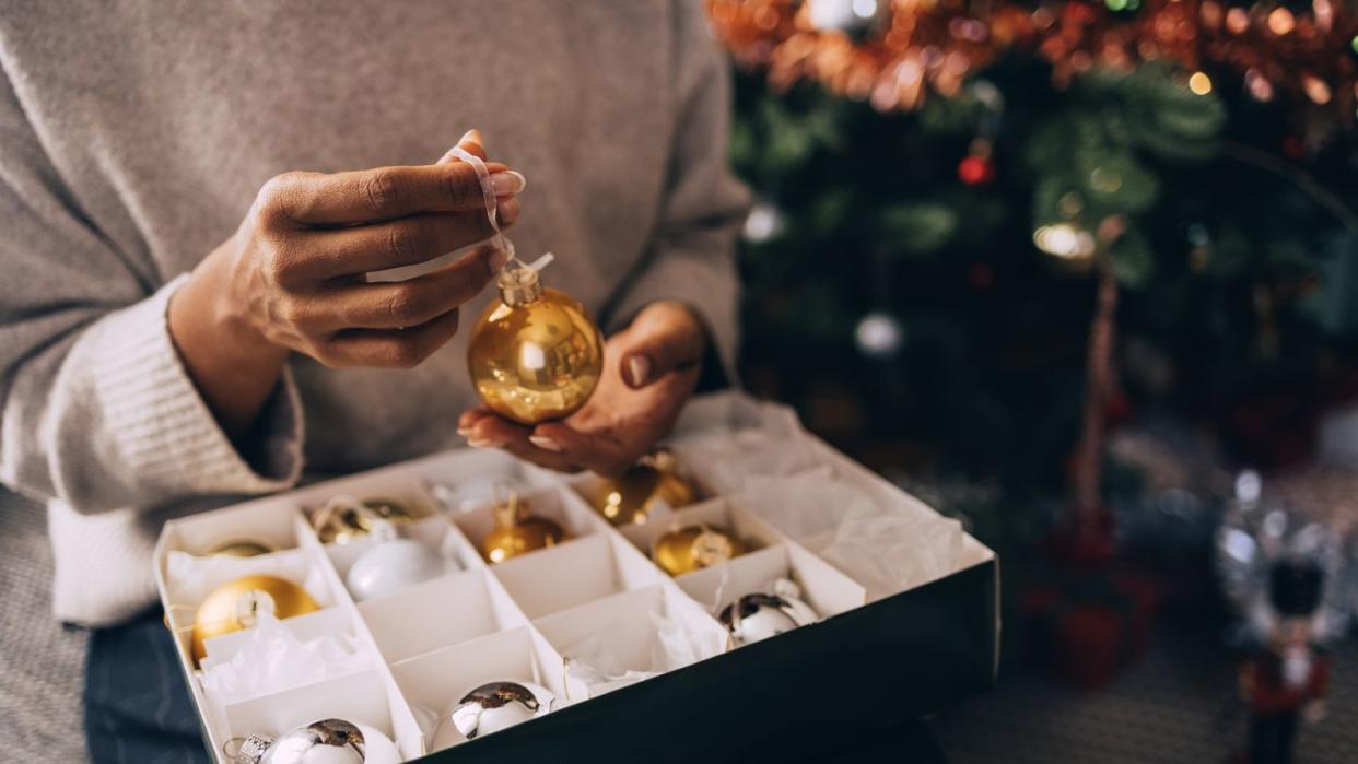 person holding a box of christmas ornaments