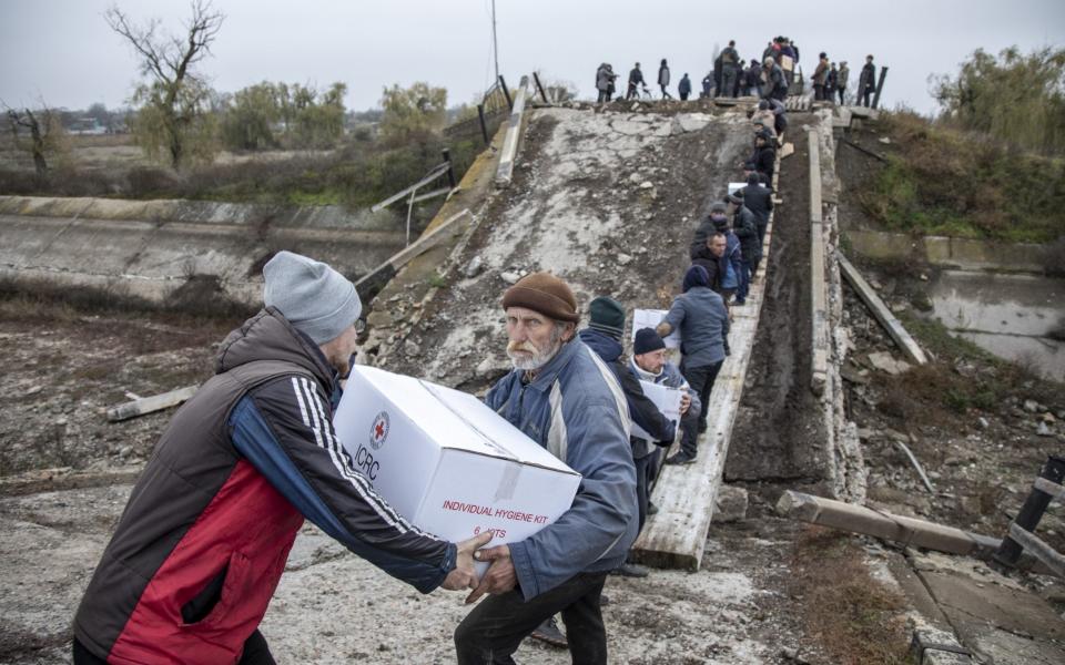 A close-up shot shows two local men passing a parcel along the chain - Narciso Contreras/Anadolu Agency