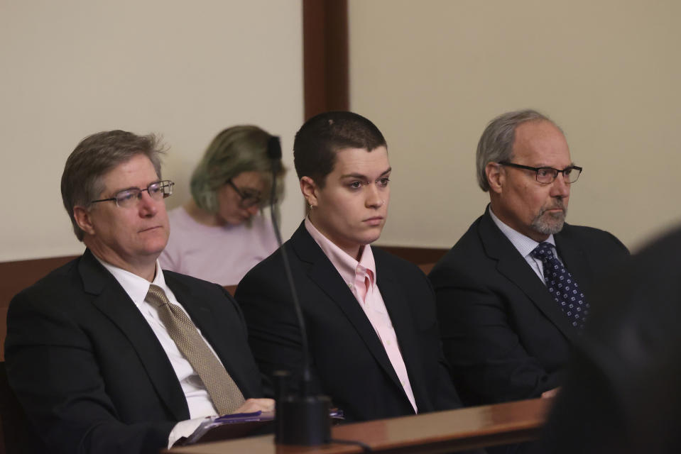 Riley Dowell, center, with an attorney, left and father, Rodney S. Dowell, right, waits during arraignment at Boston Municipal Court, Monday, Jan. 23, 2023, in Boston. Dowell, the daughter of U.S. Rep. Katherine Clark of Massachusetts was arrested during a protest Saturday night on Boston Common and later charged with assault after a police officer was injured. Dowell, 23, is accused of defacing the Parkman Bandstand Monument with spray paint before she was arrested, officials said. (David L Ryan/The Boston Globe via AP, Pool)