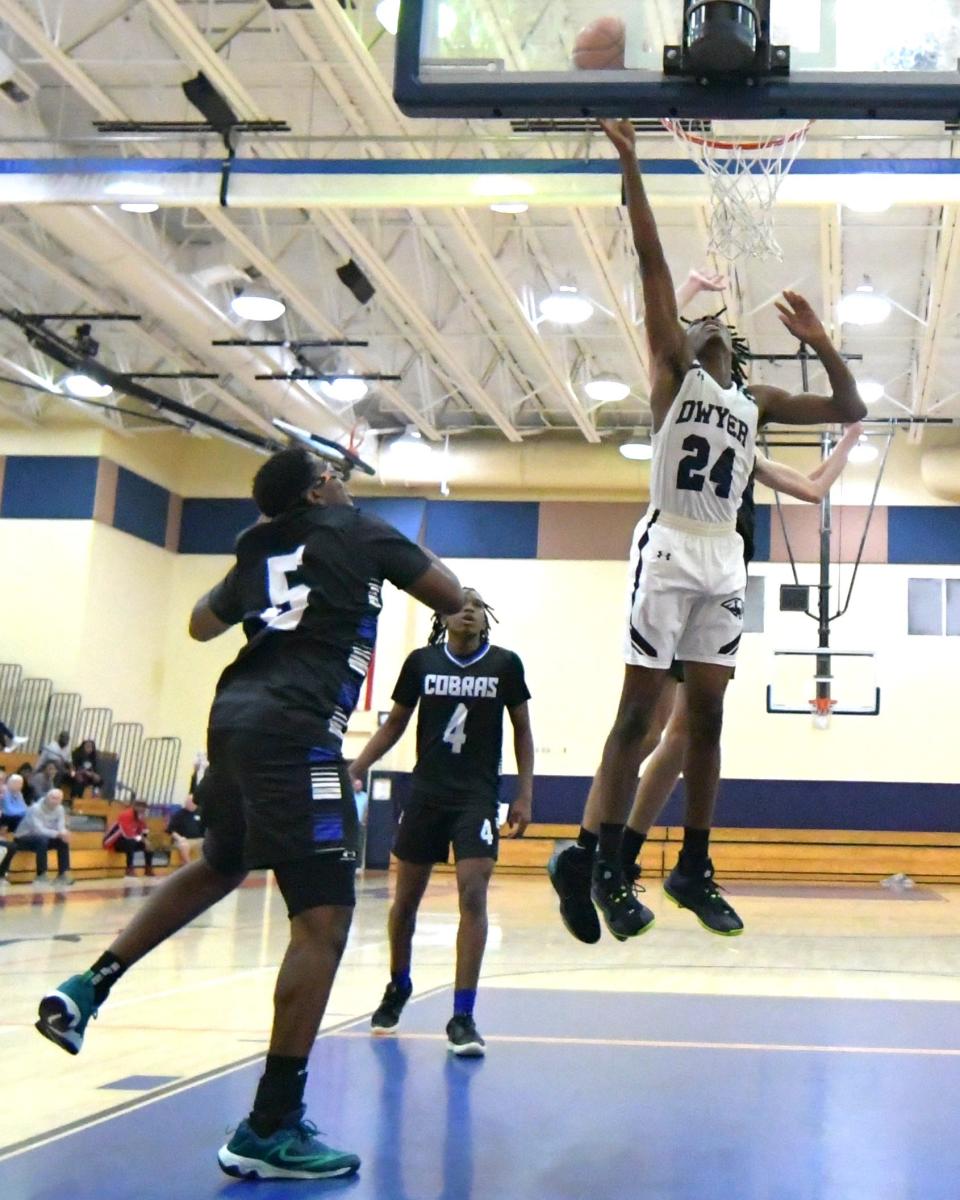 Dwyer guard Jaelen Nelson (24) goes high with Cobra defender for a lay-up during an HBC Showcase game on Dec. 28, 2023.