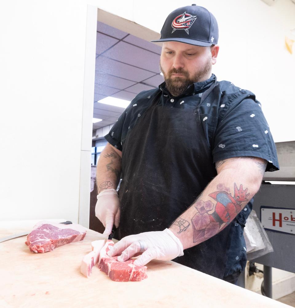 Strasburg Meats owner Kevin Davis cuts meat at his store at the Meyers Lake Plaza in Canton Township.