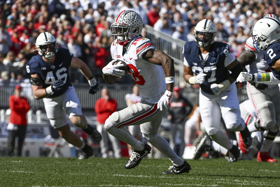 Ohio State wide receiver Marvin Harrison Jr. (18) runs away from Penn State defenders Nick Tarburton (46) and PJ Mustipher (97) during the first half of an NCAA college football game, Saturday, Oct. 29, 2022, in State College, Pa. (AP Photo/Barry Reeger)