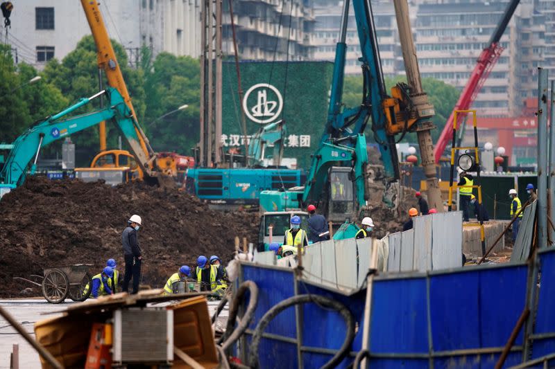 Workers wearing face masks are seen on a construction site in Wuhan