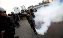 FILE PHOTO: A riot police officer fires tear gas during a protest by university students outside the Indonesian parliament in Jakarta, Indonesia