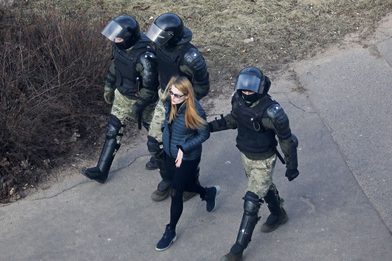 FILE PHOTO: A woman is led away by law enforcement officers, as Belarusian opposition supporters gather for a rally in Minsk