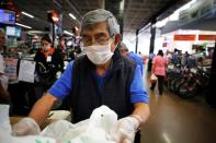 An elderly man, working as a packer at a supermarket, wears a protective face mask as a security measure for the coronavirus disease (COVID-19), in Mexico City