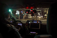 A taxi drives along an empty street in Milan, northern Italy, early Sunday, Oct. 25, 2020. Since the 11 p.m.-5 a.m. curfew took effect last Thursday, people can only move around during those hours for reasons of work, health or necessity. (AP Photo/Luca Bruno)