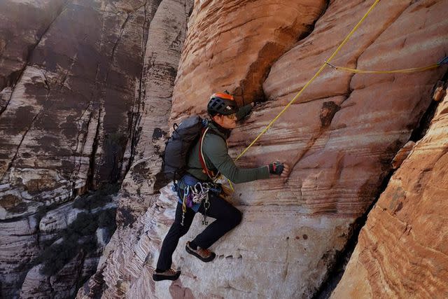 <p>Peacock</p> Orlando Bloom clings to the side of a rock in Peacock's 'To The Edge'