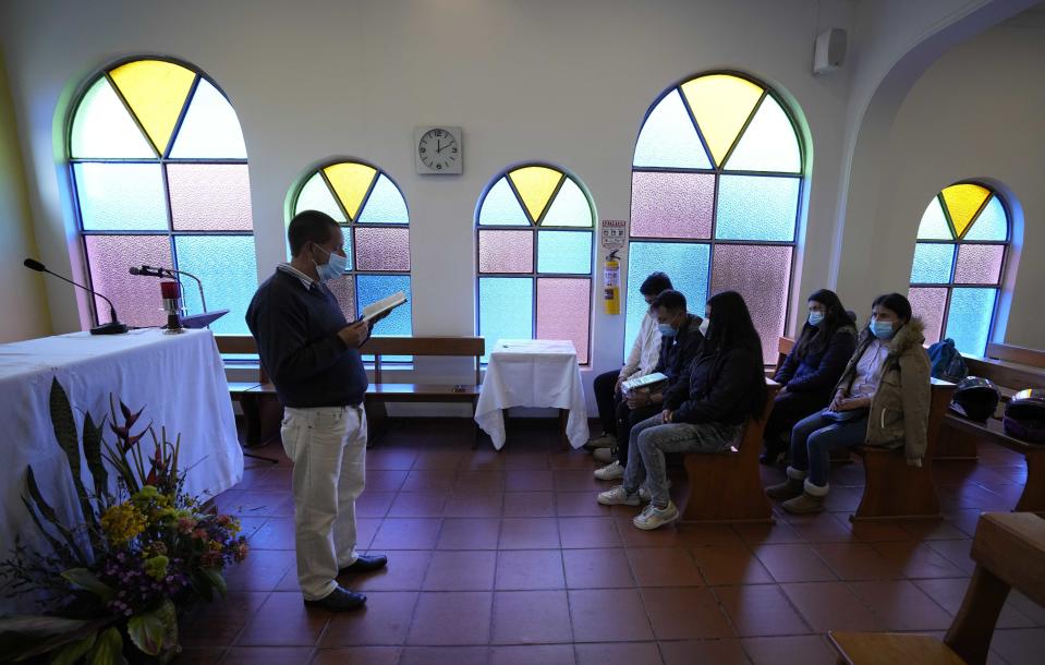 Family members attend a memorial service for a relative who died from the new coronavirus, in the chapel at the Zipaquira's Park Cemetery in Zipaquira, Colombia, Friday, June 18, 2021. Funeral workers in Colombia are struggling to dispose of bodies as the country experiences a surge in deaths from COVID-19. (AP Photo/Fernando Vergara)