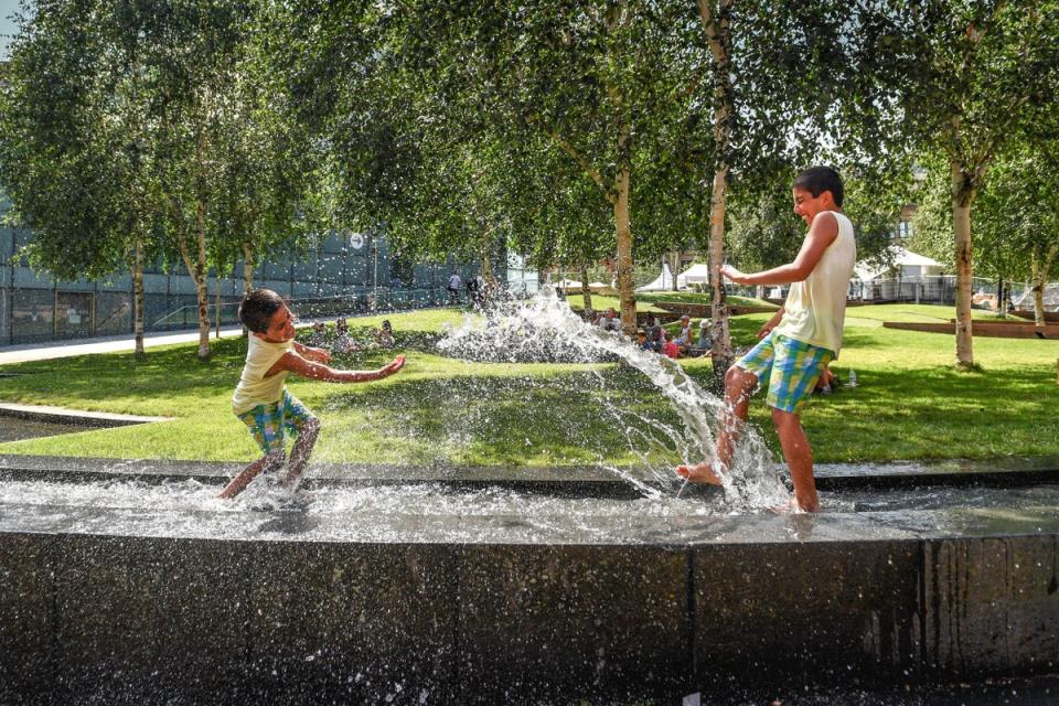 Manchester: Hamza and Haris splash in the water feature beside the National Football Museum (PA)