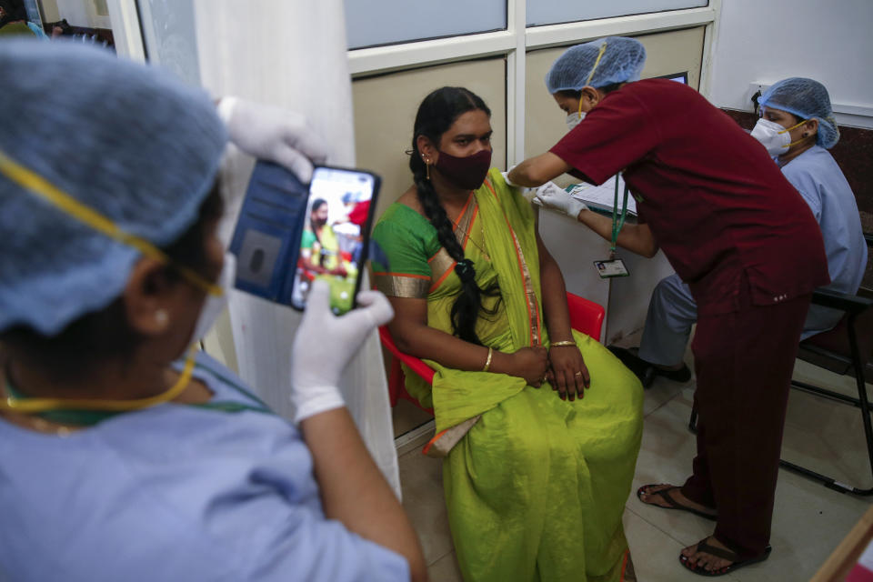 A health worker takes pictures as another administers the Covishield vaccine against the coronavirus at a vaccination program for members of the transgender community in Mumbai, India, Sunday, June 20, 2021. (AP Photo/Rafiq Maqbool)