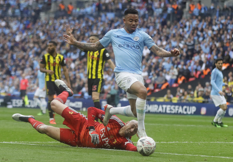 Watford's goalkeeper Heurelho Gomes tries to stop Manchester City's Gabriel Jesus during the English FA Cup Final soccer match between Manchester City and Watford at Wembley stadium in London, Saturday, May 18, 2019. (AP Photo/Kirsty Wigglesworth)