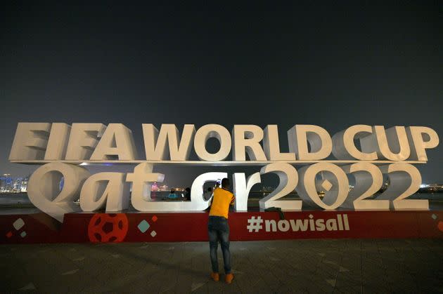 A visitor takes photos with a FIFA World Cup sign in Doha on October 30, 2022, ahead of the Qatar 2022 FIFA World Cup soccer tournament.