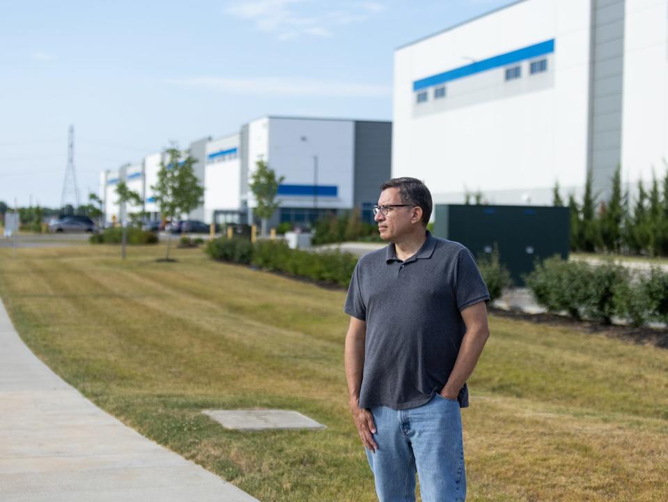 Bruce Miller stands in front of an Amazon warehouse.