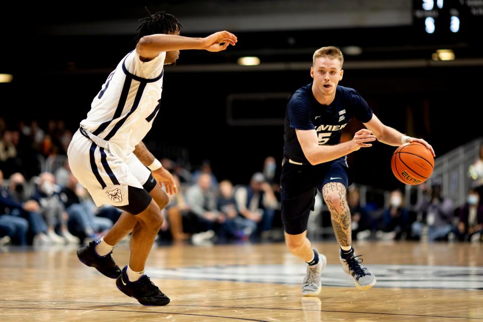 Xavier Musketeers guard Adam Kunkel (5) drives on Butler Bulldogs guard Jayden Taylor (13) in the second half of the NCAA men's basketball game on Friday, Jan. 7, 2022, at Hinkle Fieldhouse in Indianapolis, Ind. Xavier Musketeers defeated Butler Bulldogs 87-72. 