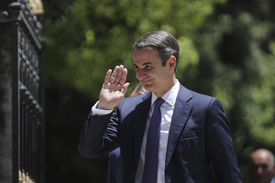 Greece's newly-elected prime minister Kyriakos Mitsotakis, waves as he walks shortly after his swearing-in ceremony at the Presidential Palace in Athens, Monday, July 8, 2019. Mitsotakis' New Democracy party won 39.8% of the vote, giving him 158 seats in the 300-member parliament, a comfortable governing majority. (AP Photo/Petros Giannakouris)