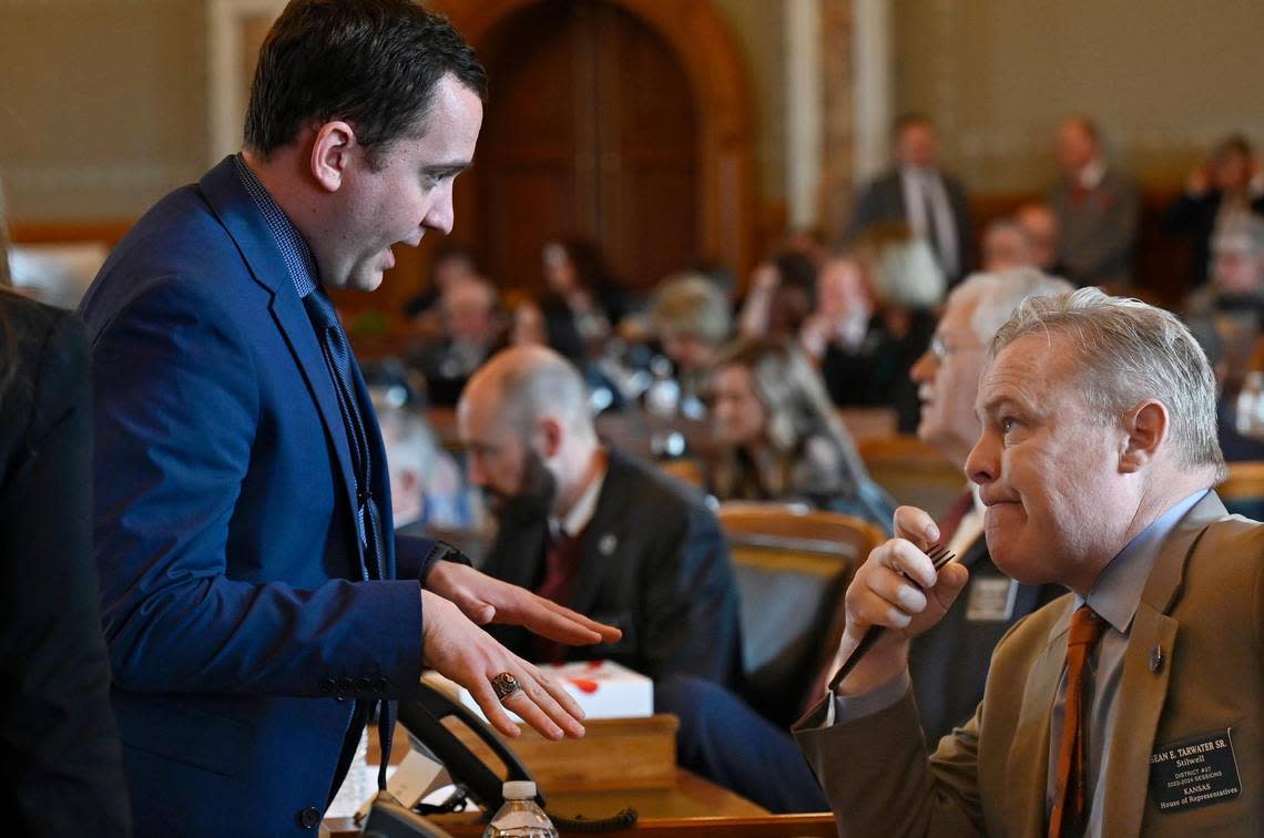 Speaker Pro Tem Blake Carpenter, left, a Derby Republican, talks with Rep. Sean Tarwater, a Stillwell Republican. Carpenter, who once juggled four jobs, has felt the pain of the low legislative salaries.