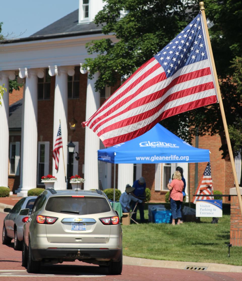 Vehicles are lined up to exchange old flags for new ones at the 2021 flag exchange hosted by Gleaner Life Insurance Society in Adrian.