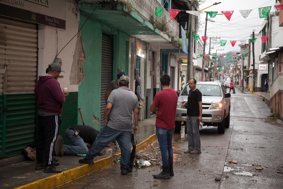 People clean debris after yesterday's 7.7-earthquake in Coalcoman, Michoacan, Mexico, on 20 September 2022 (EPA)