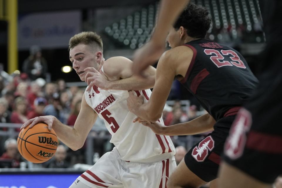 Wisconsin's Tyler Wahl drives past Stanford's Brandon Angel during the first half of an NCAA college basketball game Friday, Nov. 11, 2022, in Milwaukee. The game is being played at American Family Field, home of the Milwaukee Brewers. (AP Photo/Morry Gash)