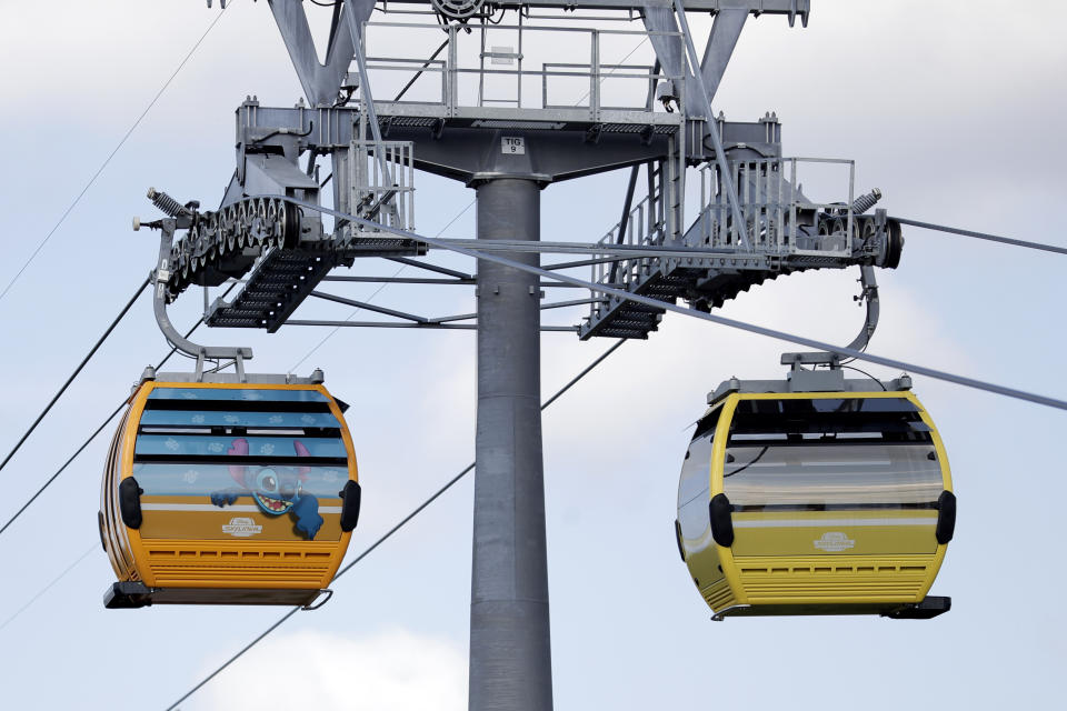 Gondolas move to various locations at Walt Disney World on the Disney Skyliner aerial tram, Friday, Sept. 27, 2019, in Lake Buena Vista, Fla. The Disney Skyliner gondolas opening to visitors on Sunday are the latest addition to one of the largest private transportation systems in the U.S.(AP Photo/John Raoux)