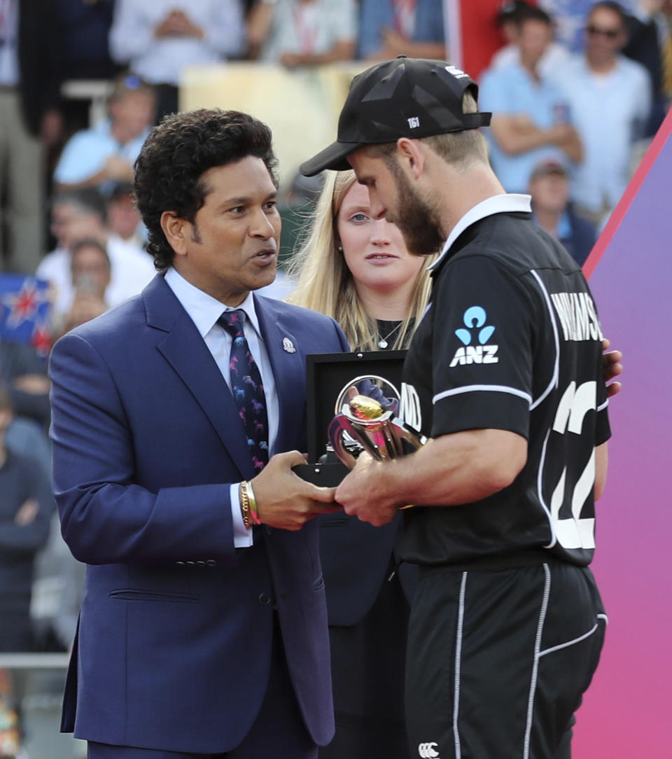 New Zealand's captain Kane Williamson receives the runners-up trophy from former Indian cricketer Sachin Tendulkar after his team lost the Cricket World Cup final match between England and New Zealand at Lord's cricket ground in London, England, Sunday, July 14, 2019. (AP Photo/Aijaz Rahi)