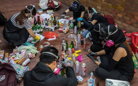 Protesters make molotov cocktails while camped out at the city's Polytechnic University  - Credit: AFP