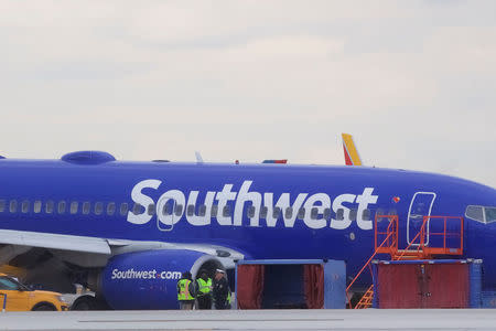 Emergency personnel monitor the damaged engine of Southwest Airlines Flight 1380, which diverted to the Philadelphia International Airport this morning after the airline crew reported damage to one of the aircraft's engines, on a runway in Philadelphia, Pennsylvania U.S. April 17, 2018. REUTERS/Mark Makela