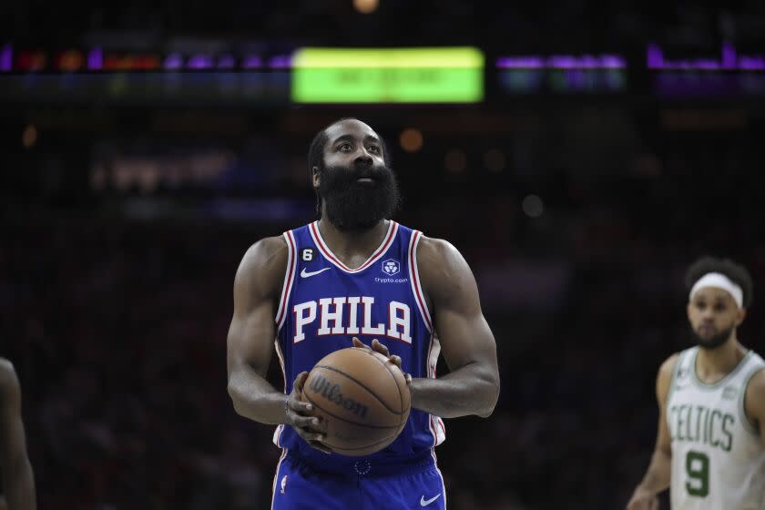 The Philadelphia 76ers' James Harden stands at free-throw line with the ball in his hands and looks to the basket