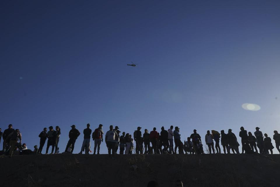 Migrants watch from the Mexican side of the border as others cross the Rio Grande into the United States from Ciudad Juarez, Mexico, in March 2023. (AP Photo/Fernando Llano)