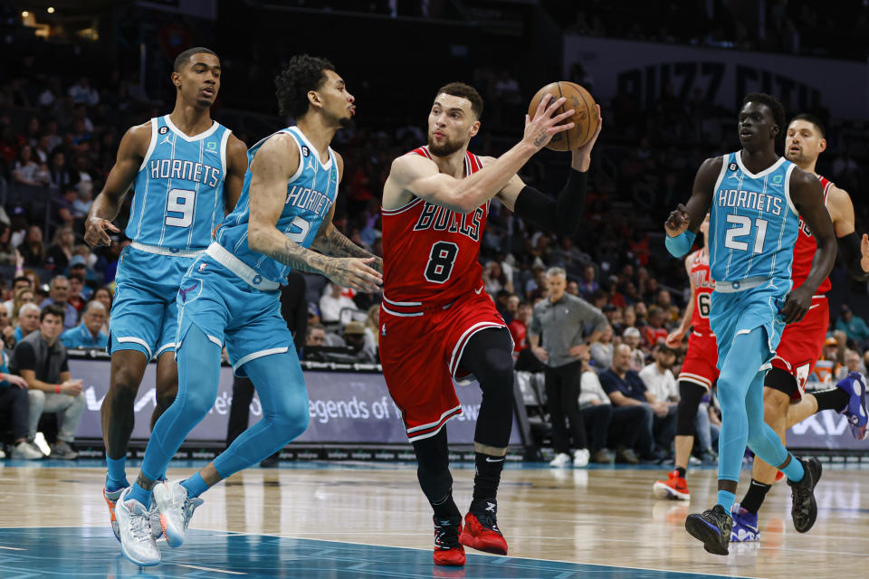 Chicago Bulls guard Zach LaVine (8) drives to the basket against Charlotte Hornets guard James Bouknight (2) as guard Theo Maledon (9) and forward JT Thor (21) watch during the first half of an NBA basketball game in Charlotte, N.C., Friday, March 31, 2023. (AP Photo/Nell Redmond)