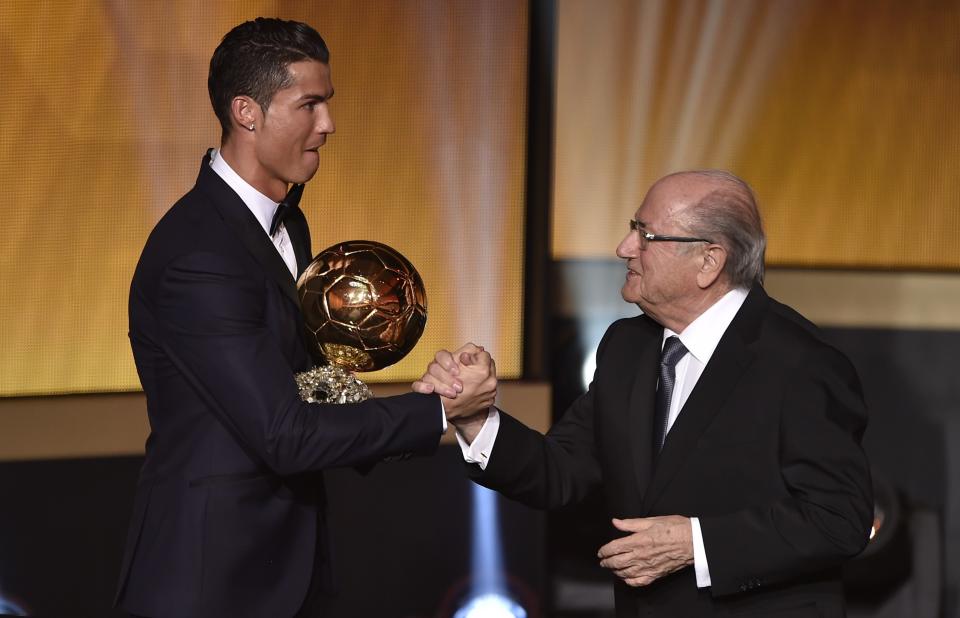 Real Madrid and Portugal forward Cristiano Ronaldo (L) shakes hands with FIFA president Sepp Blatter (R) after receiving the 2014 FIFA Ballon d'Or award for player of the year during the FIFA Ballon d'Or award ceremony at the Kongresshaus in Zurich on January 12, 2015. AFP PHOTO / FABRICE COFFRINI (Photo credit should read FABRICE COFFRINI/AFP via Getty Images)