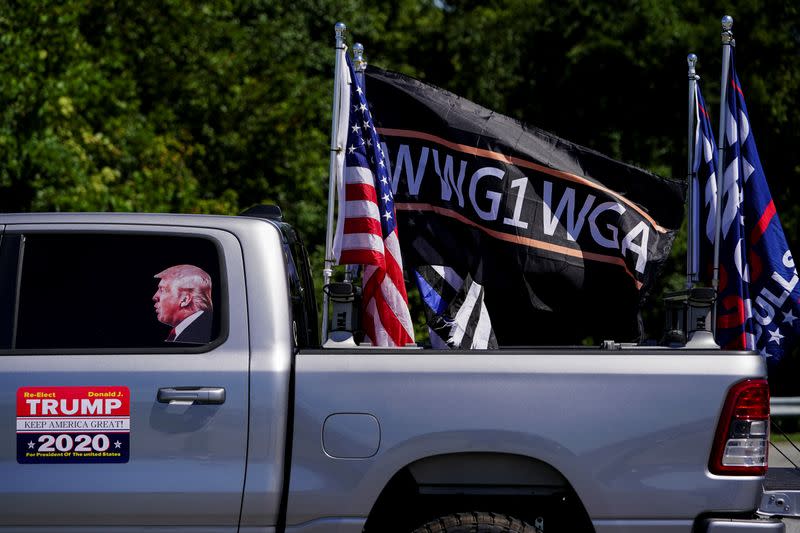 Pro-Trump flags and a flag reading WWG1WGA, a reference to the QAnon slogan is seen on a truck that participated in a caravan convoy in Adairsville