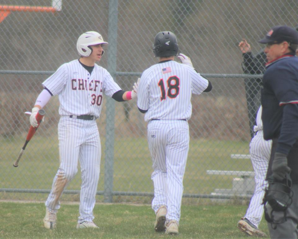 Cheboygan senior Eli Couture (30) congratulates sophomore teammate James Charboneau (18), who scored during game one of a varsity baseball doubleheader against Rudyard on Thursday.