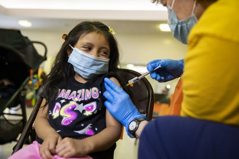 Stephanie Gonzalez, 5, watches as registered nurse Tatiana Solobaeva administers Stephanie's first COVID-19 vaccine at a vaccination clinic hosted by Los Angeles County Public Health at Balboa Sports Complex in Encino, Calif., on Saturday May 21, 2022. COVID-19 booster shots are now available for children ages 5-11 in Los Angeles County and LA County Public Health is encouraging parents to bring eligible children to vaccination sites to get boosted before summer vacation and holiday travel. (Alisha Jucevic/For The Times)