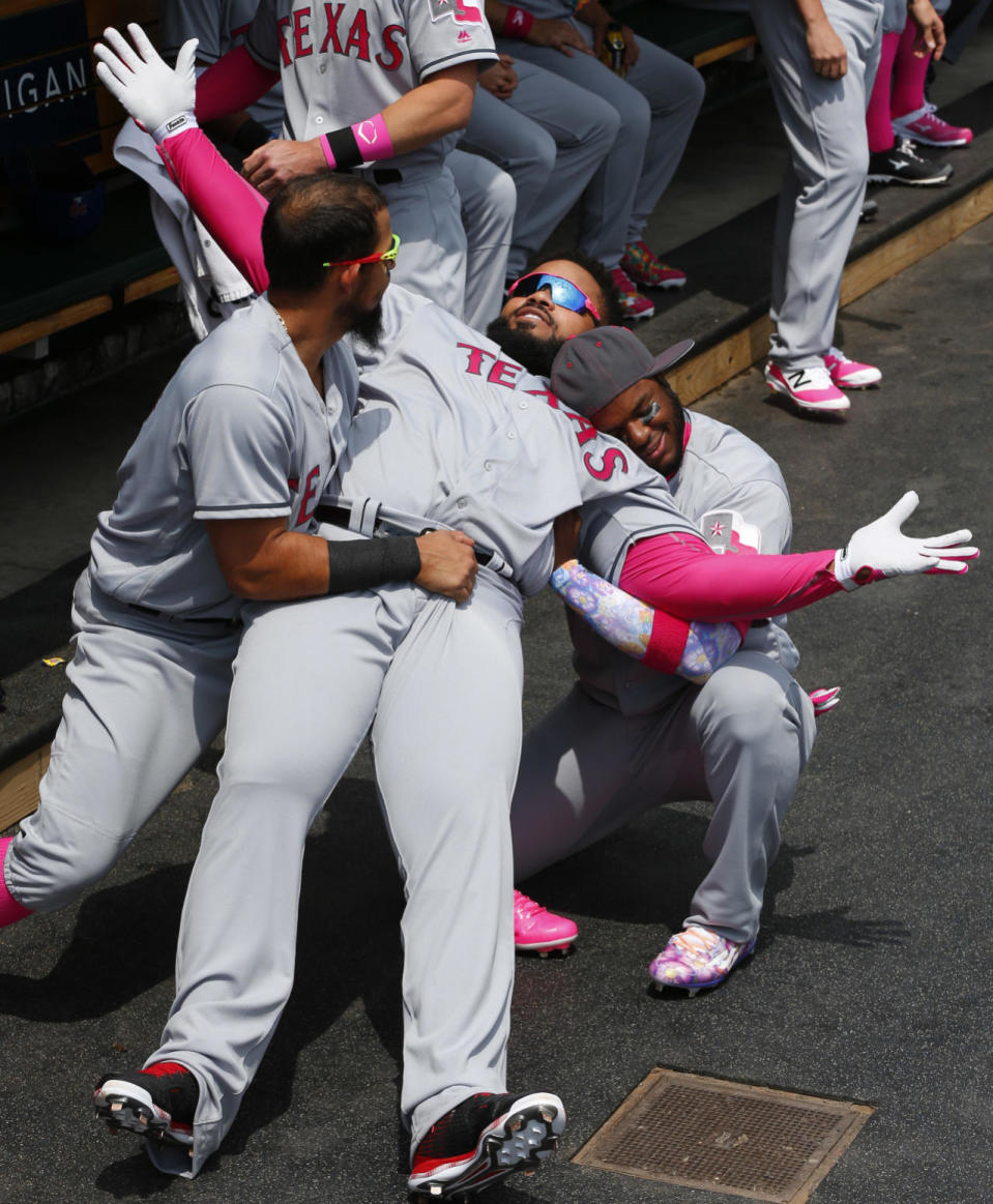 Texas Rangers’ Prince Fielder raises his arms as Rougned Odor, left, and Elvis Andrus, right, catch him falling backward in the dugout before a baseball game against the Detroit Tigers, May 8, 2016 in Detroit. (Paul Sancya/AP)