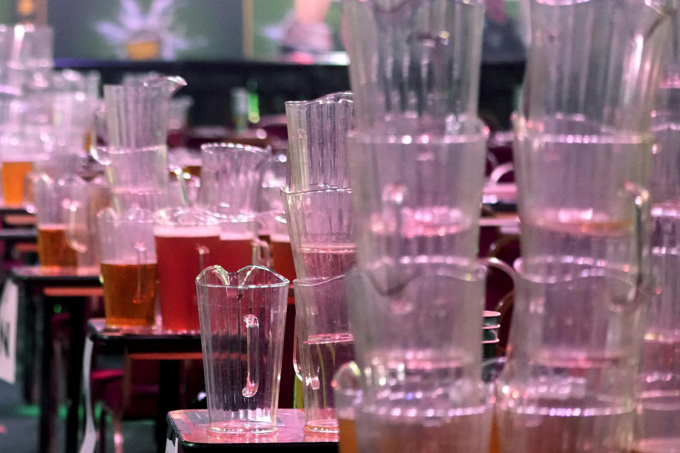 Beer jugs are stacked by the cleaning staff after the end of play in the quarterfinals at the World Darts Championship at Alexandra Palace in London, Monday, Jan. 1, 2024. (AP Photo/Kin Cheung)