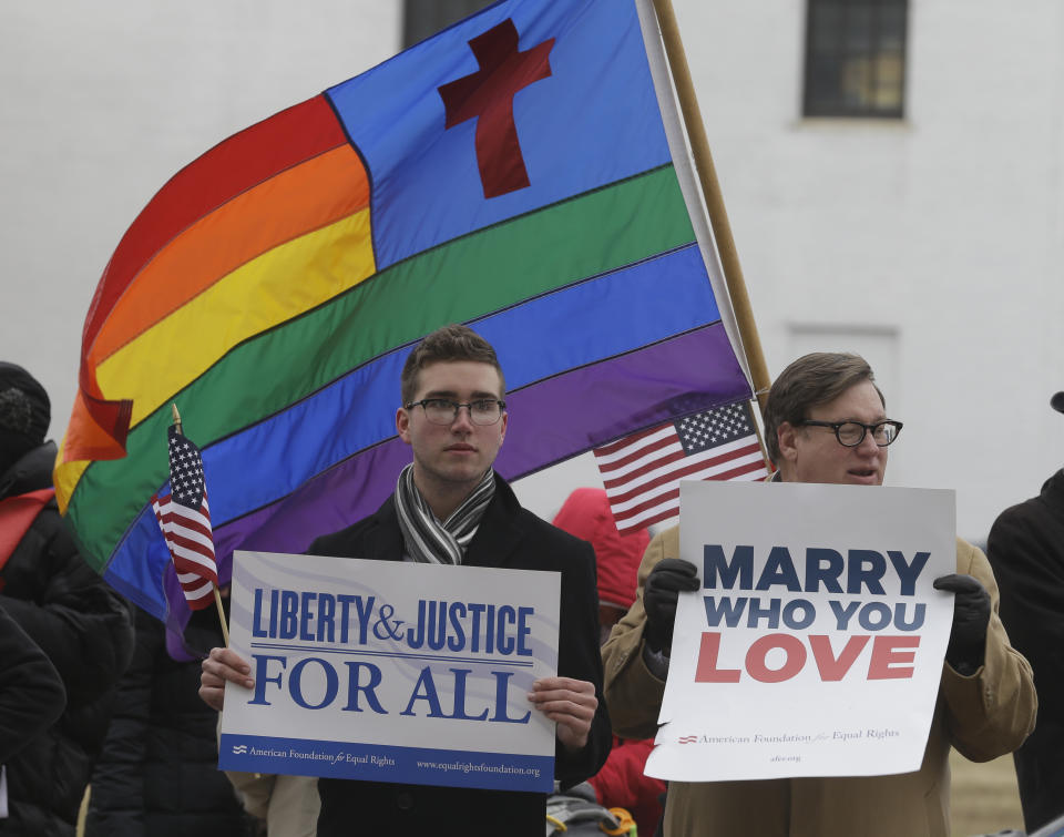 Spencer Geiger, left, of Virginia Beach, and Carl Johanson, of Norfolk, hold signs as they demonstrate outside Federal Court in Norfolk, Va., Tuesday, Feb. 4, 2014. A federal judge heard arguments on whether Virginia's ban on gay marriage is unconstitutional. (AP Photo/Steve Helber)