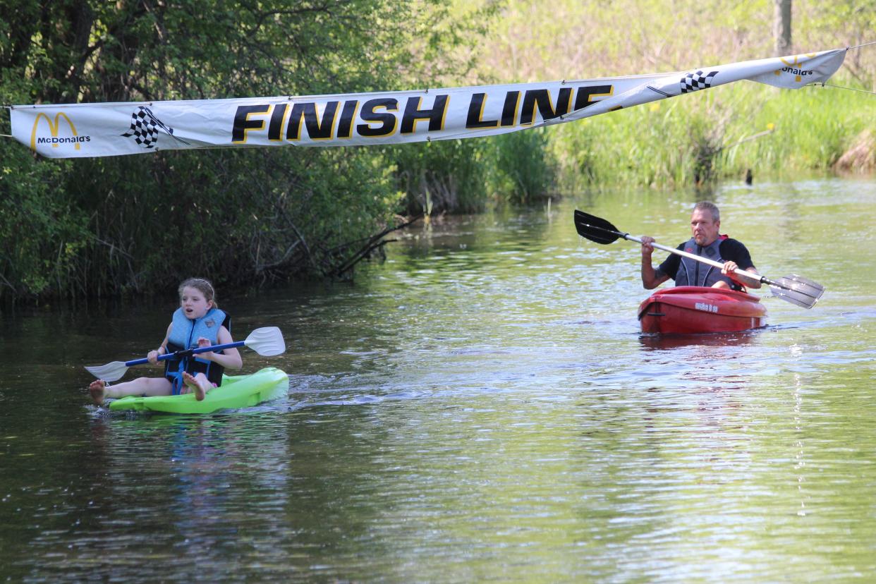 Kayakers make their way across the finish line Saturday during Riverfest in downtown Jonesville.