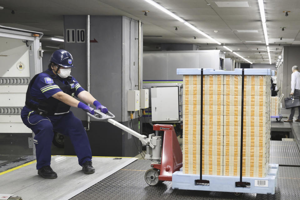 New banknotes are pulled to a vehicle to transport them to financial institutions, at the Bank of Japan headquarters in Tokyo, Japan, Wednesday, July 3, 2024. (Japan Pool/Kyodo News via AP)