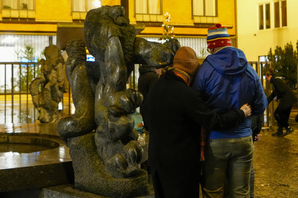 People stand during a vigil outside the building of Philosophical Faculty of Charles University in downtown Prague, Czech Republic, Thursday, Dec. 21, 2023. A mass shooting in downtown Prague killed several people and injured others, and the person who opened fire also is dead, Czech police and the city's rescue service said Thursday. (AP Photo/Petr David Josek)