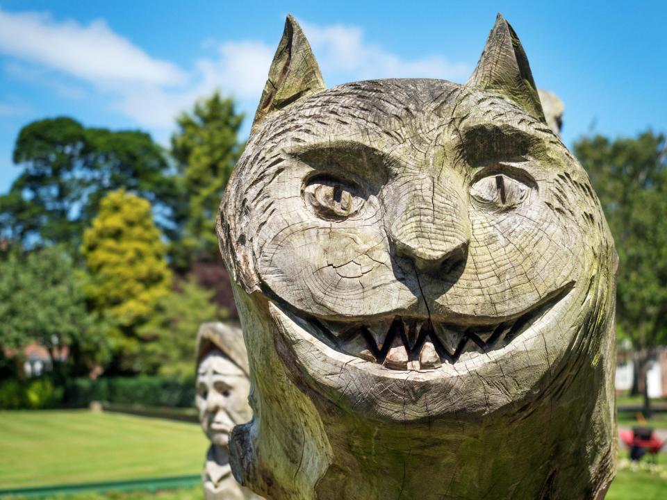 A wooden sculpture of the Cheshire Cat in the Spa Gardens in Ripon, North Yorkshire