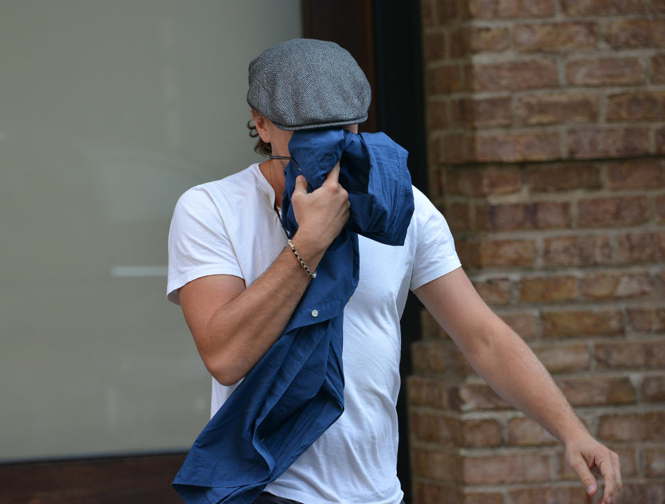 Leonardo DiCaprio hides his face behind a shirt. (Photo: Splash News)