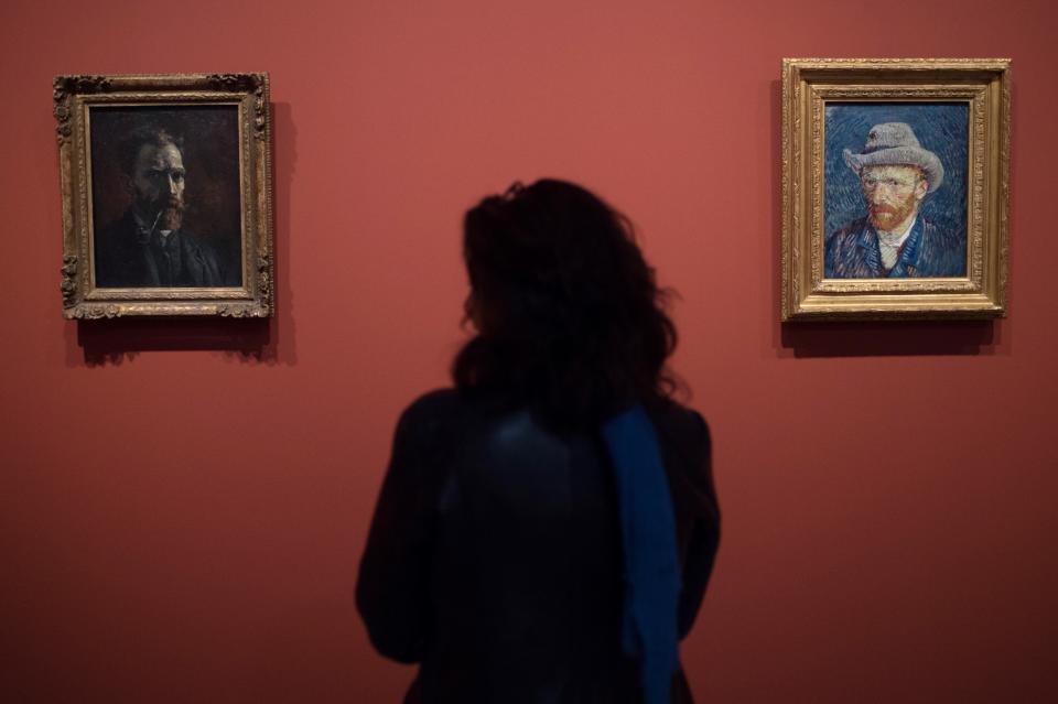 A woman looks paintings by Vincent Van Gogh entitled 'Self-Portrait with Pipe' and 'Self-Portrait with Grey Felt Hat' during the exhibition 'Van Gogh in Provence: Modernizing Tradition' at the Fondation Vincent Van Gogh Arles on May 13, 2016 in Arles, southern France.&nbsp;